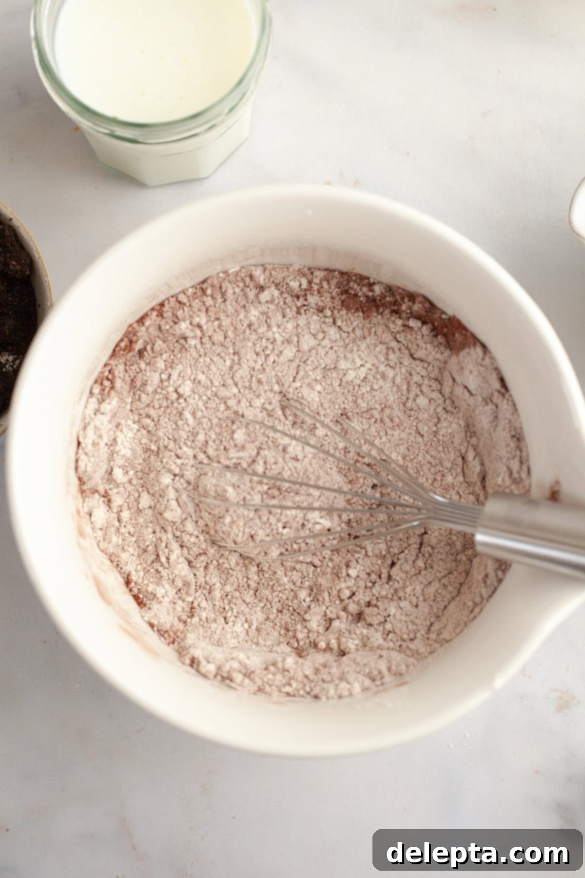 Red Velvet Oreo Cake with Oreo Buttercream 4 A white bowl with flour and cocoa powder in it, ready to be mixed.