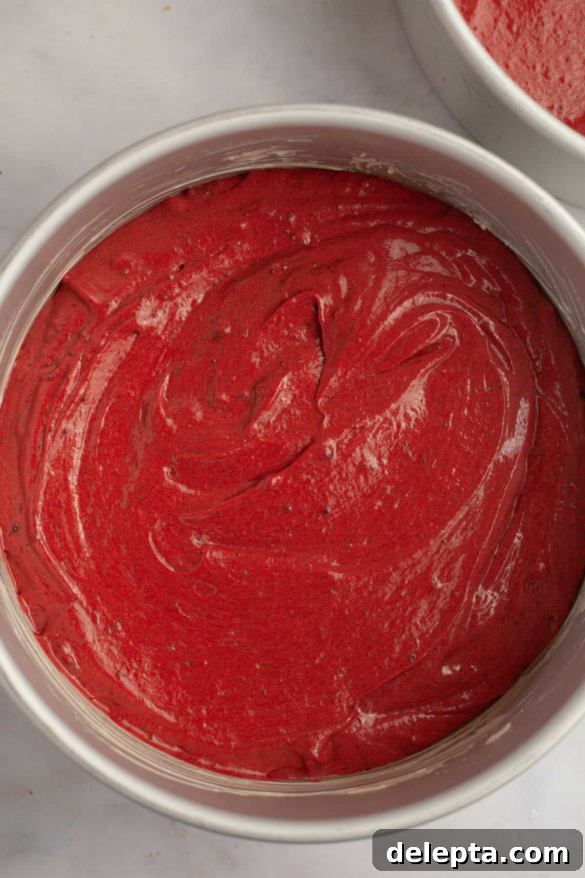 Red Velvet Oreo Cake with Oreo Buttercream 9 Unbaked red velvet Oreo cake batter evenly distributed in two round cake pans, ready for the oven.