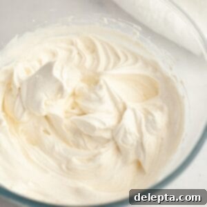 Simple Homemade Vanilla Bean Whipped Cream 6 A glass bowl with vanilla bean whipped cream, perfectly whipped and ready to serve.