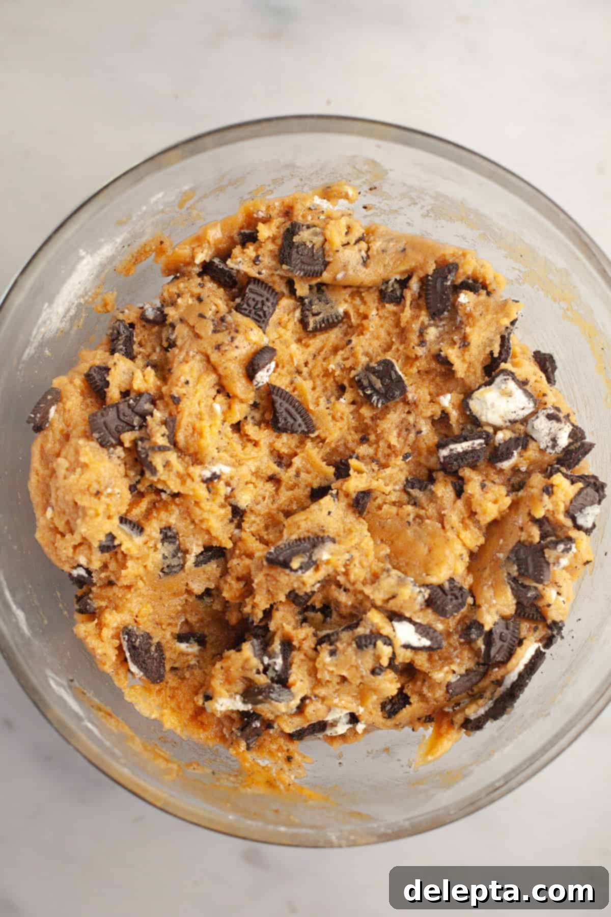 One Bowl Brown Butter Peanut Butter Oreo Perfection 8 Peanut butter cookie dough with chopped Oreos in a glass bowl.
