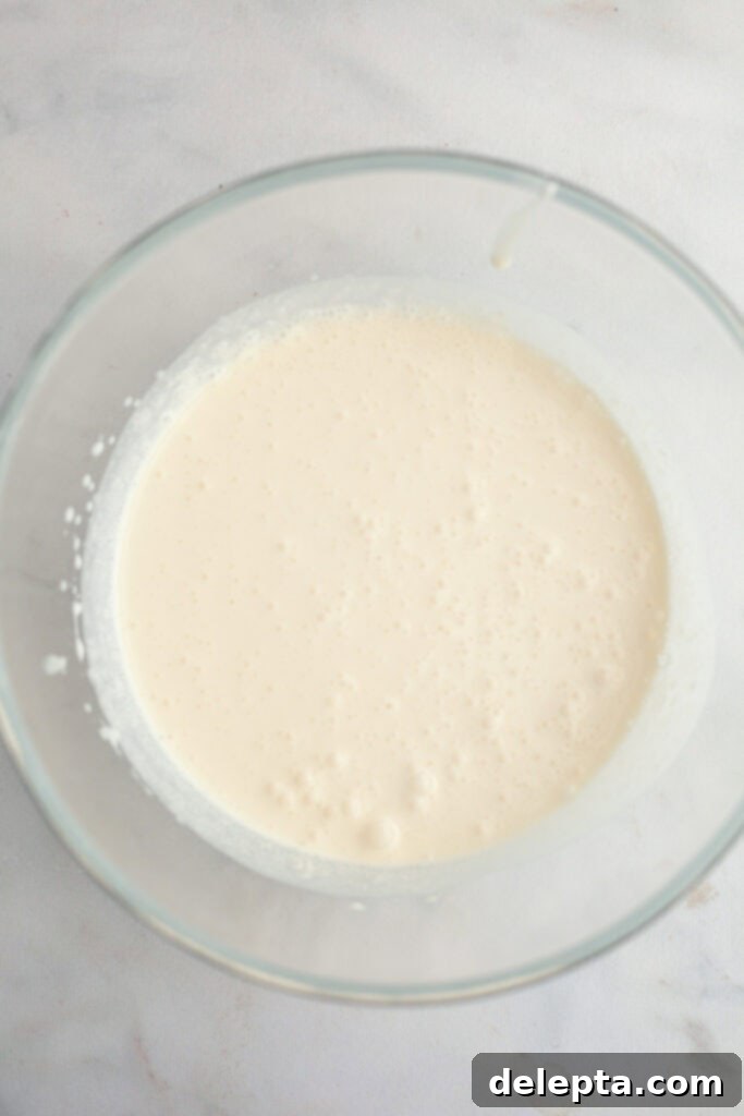 Berry Vanilla Mascarpone Bliss 7 A large glass bowl with cold heavy cream, ready to be whipped for frosting.