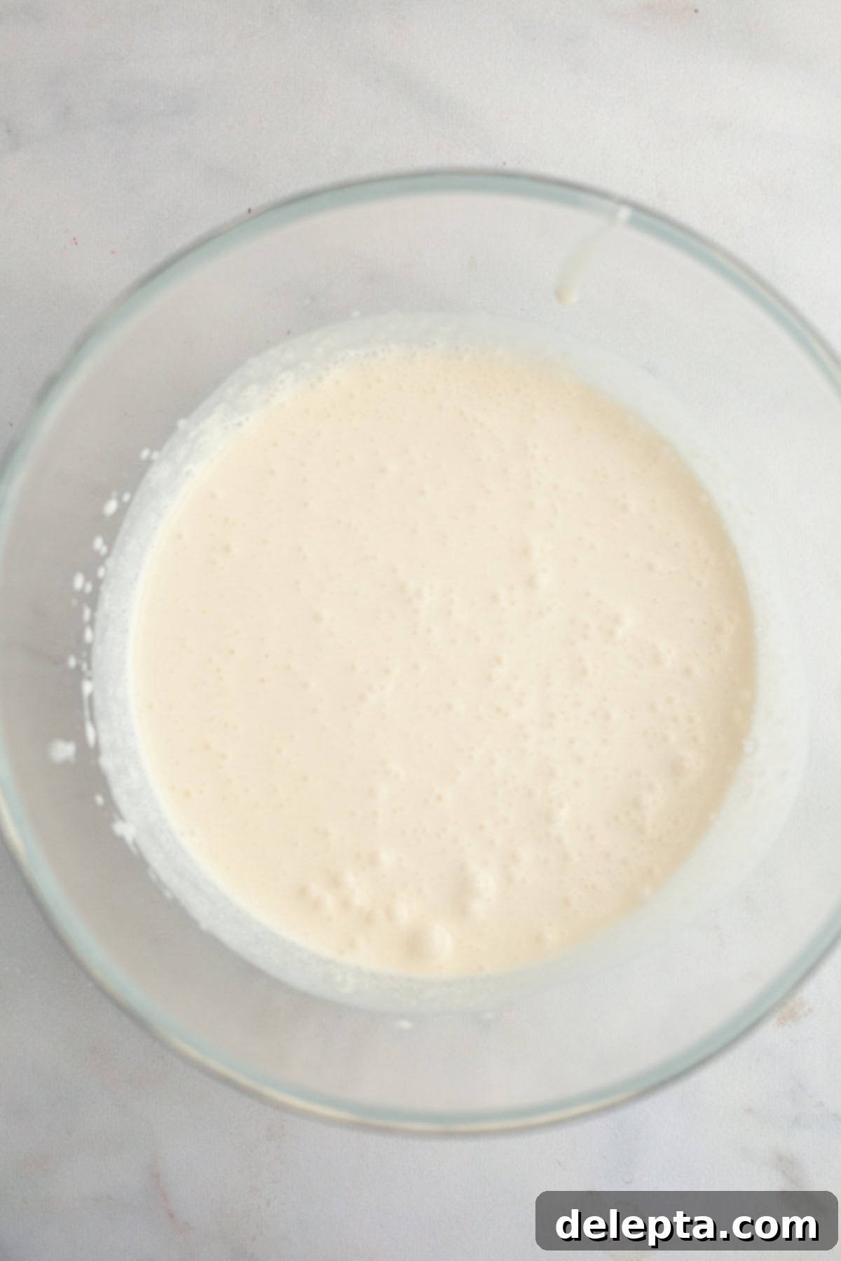 Dreamy 5-Ingredient Mascarpone Whipped Cream Frosting 4 A large glass bowl with heavy cream in it.
