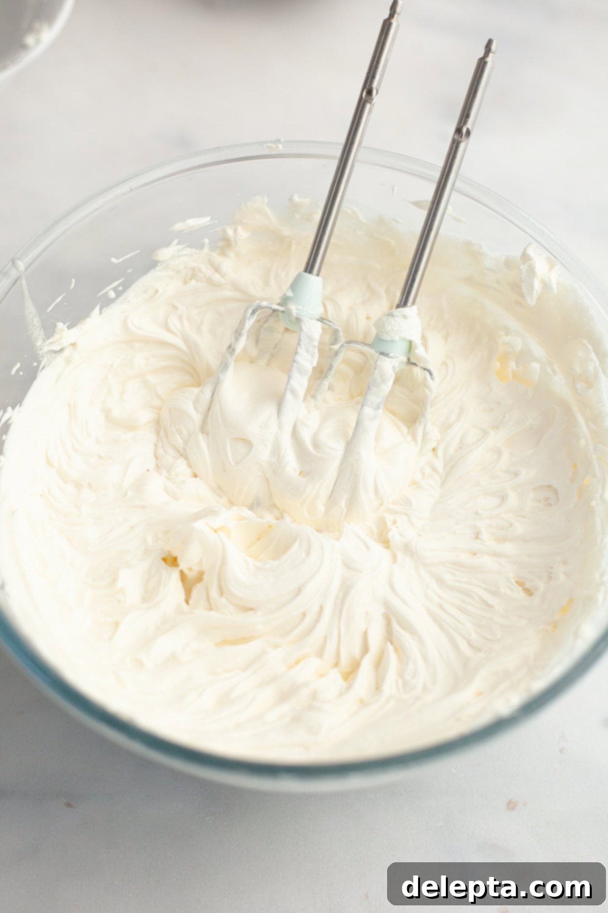 Dreamy 5-Ingredient Mascarpone Whipped Cream Frosting 6 A large glass bowl filled with mascarpone whipped cream frosting.