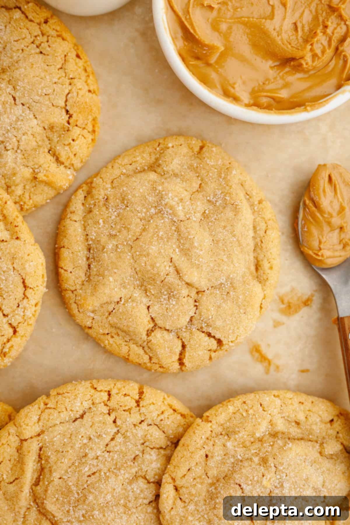 Golden Brown Butter Peanut Butter Cookies Ready Now 9 Freshly baked brown butter peanut butter cookies cooling on brown parchment paper, showcasing their golden color and crinkled tops.