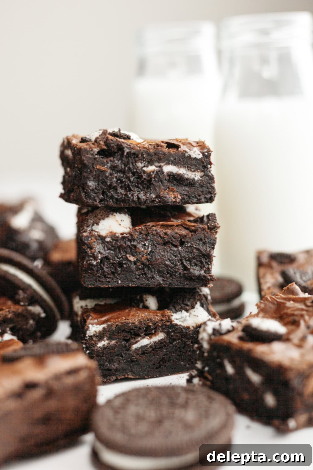 One-Bowl Decadence: Oreo Fudge Brownies 2 A stack of three incredibly fudgy Oreo brownies with a crinkly top and visible Oreo chunks.