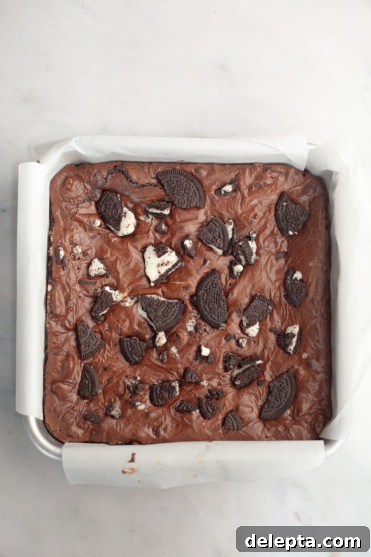 One-Bowl Decadence: Oreo Fudge Brownies 9 A freshly baked pan of fudgy Oreo brownies, showcasing the shiny, crinkly top and golden edges.