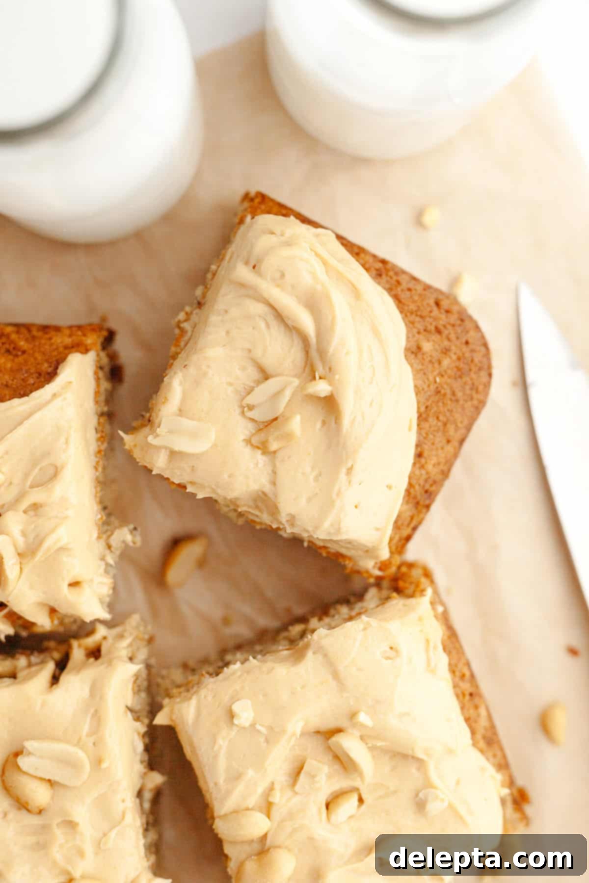 Banana Peanut Butter Bliss 11 Square slices of banana cake generously topped with peanut butter frosting and salted peanuts, arranged on a serving platter.