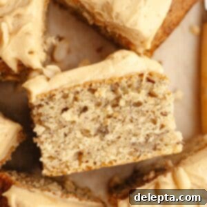 Banana Peanut Butter Bliss 12 A close up of a slice of banana cake with peanut butter frosting, presented on its side.