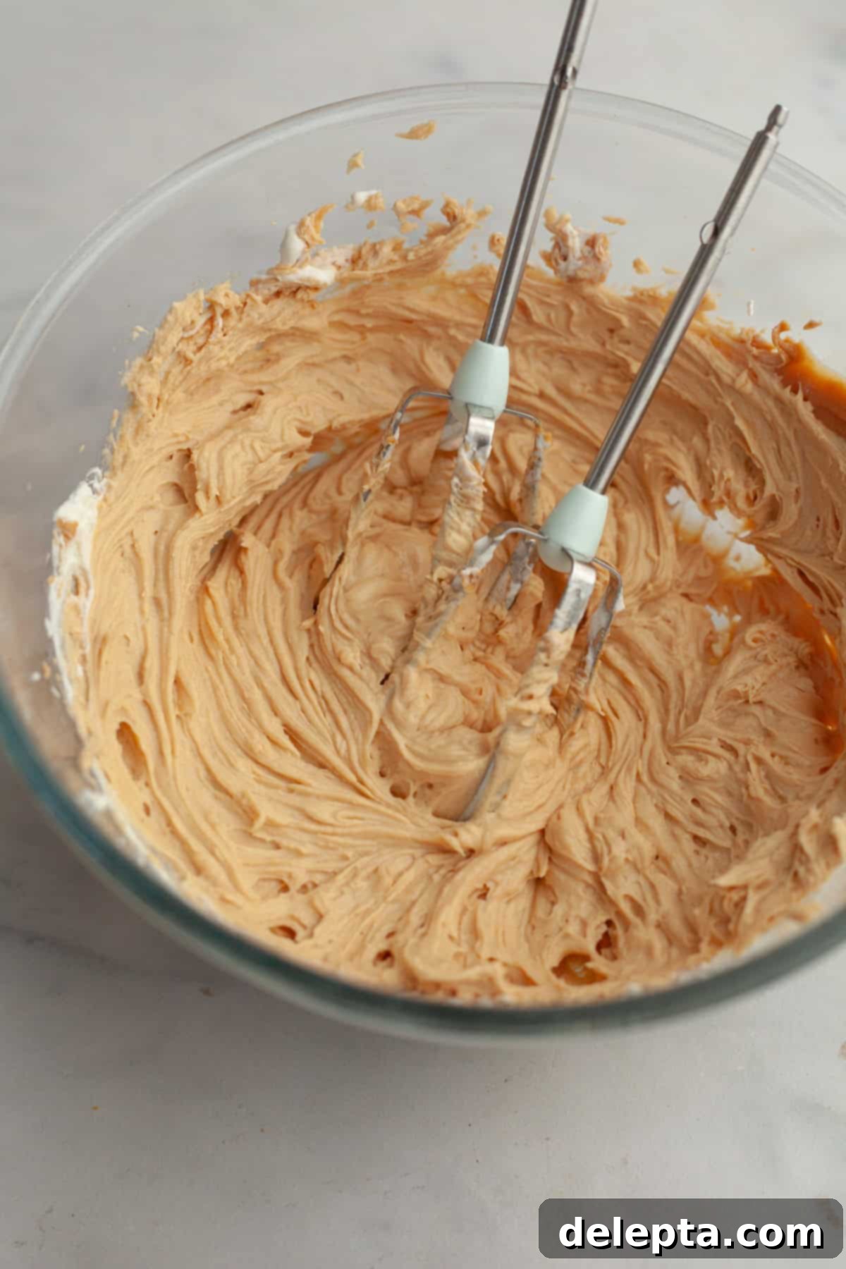 Banana Peanut Butter Bliss 9 Creamy peanut butter frosting in a glass bowl, ready to be spread onto the banana cake.