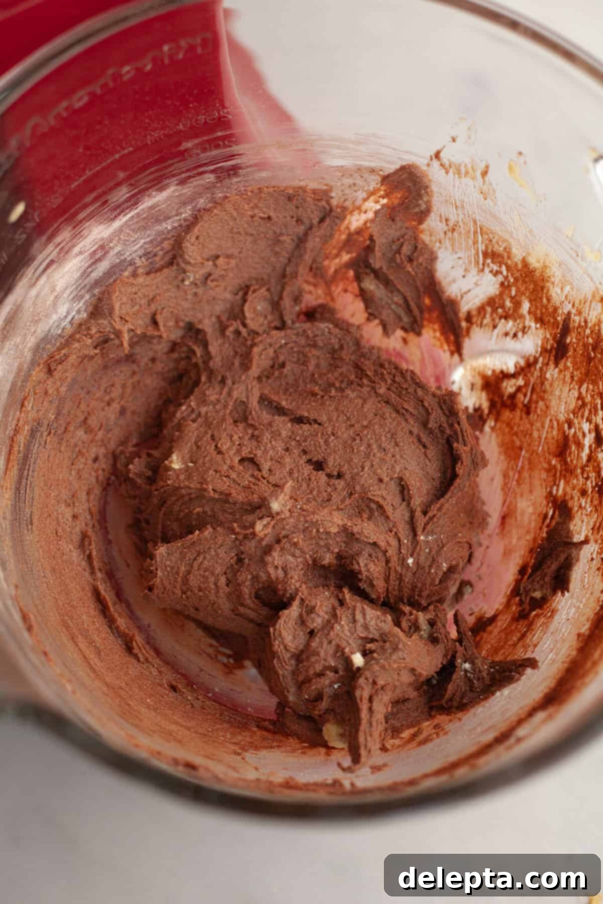 Gooey Pistachio Stuffed One Bowl Chocolate Cookies 7 Rich, dark chocolate cookie dough in a glass bowl, showing a uniform mixture of dry and wet ingredients.