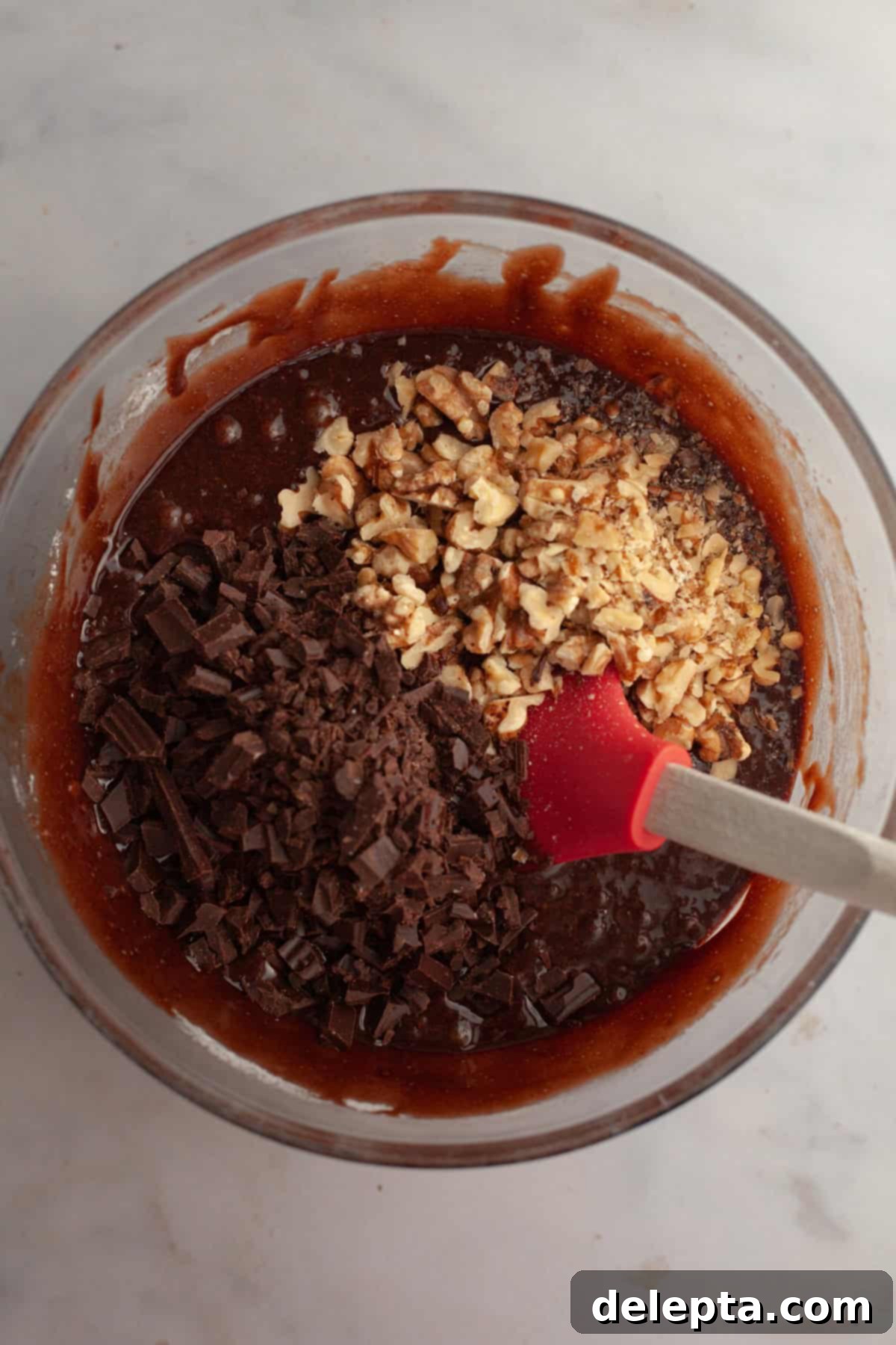 One Bowl Wonder Fudgy Walnut Brownies 6 Brownie batter in a glass bowl with chopped chocolate and toasted walnuts.