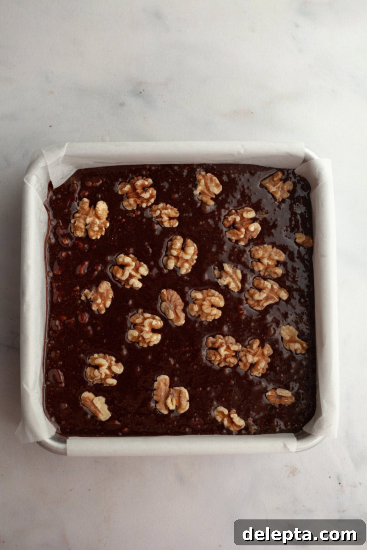 One Bowl Wonder Fudgy Walnut Brownies 7 Unbaked walnut brownies in a square pan.