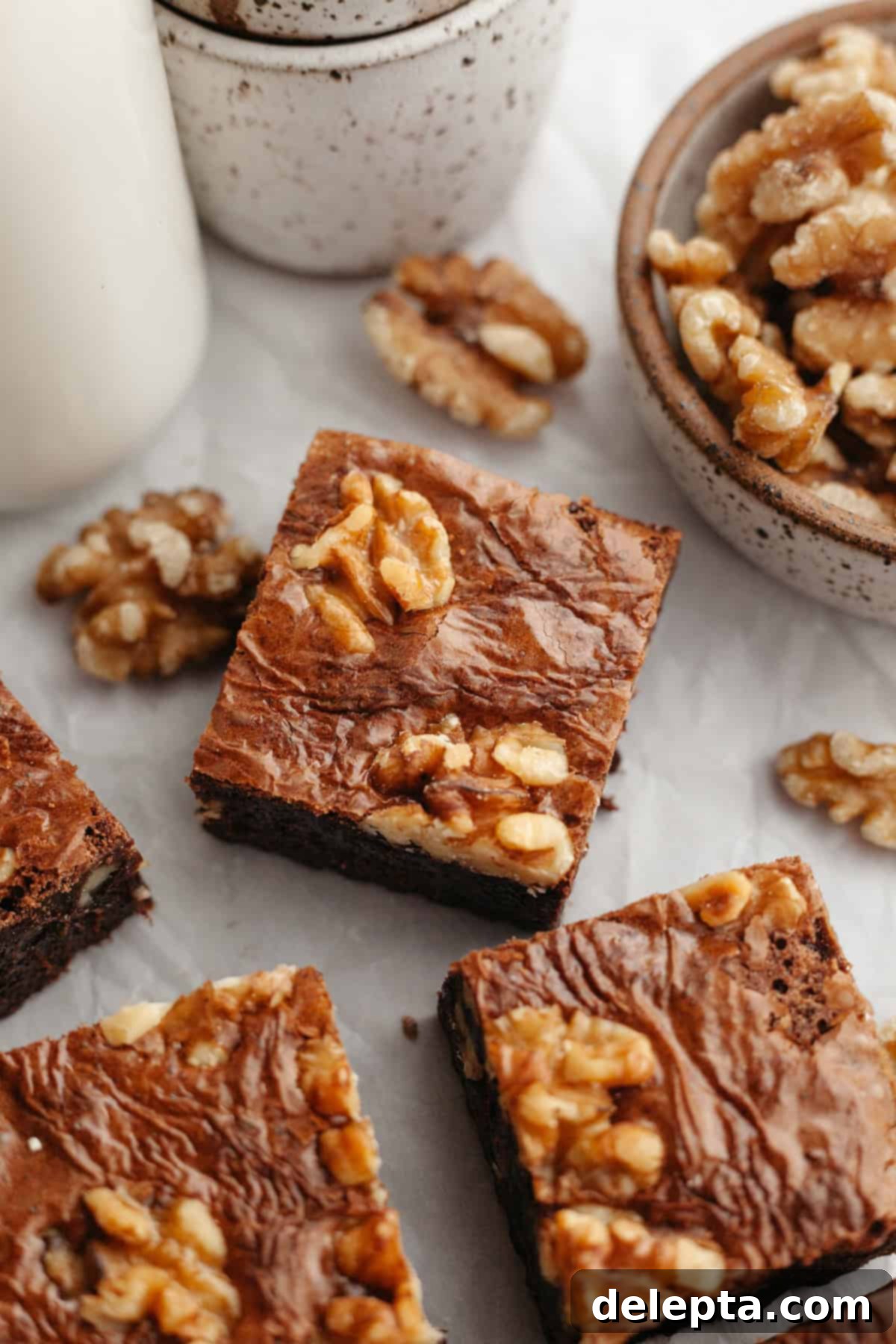 One Bowl Wonder Fudgy Walnut Brownies 9 A close up of sliced fudgy walnut brownies on parchment paper.
