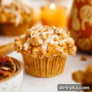 Harvest Pumpkin Pecan Crunch Muffins 10 A close up of a pumpkin pecan muffin with a white glaze.