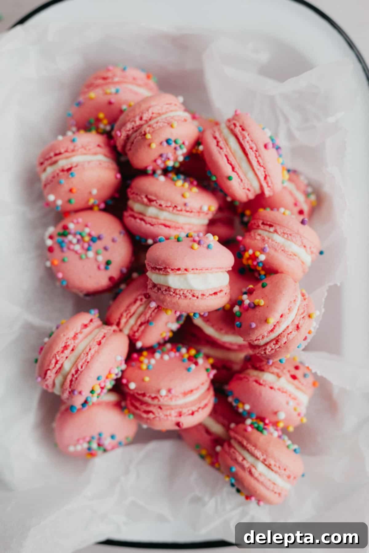 Funfetti Macarons 2 pink and sprinkle macarons on parchment paper