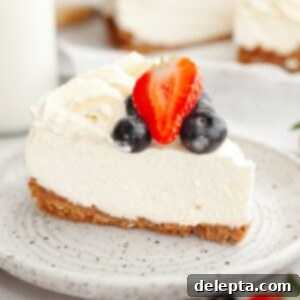 Gelatin-Free No-Bake Vanilla Cheesecake 11 A slice of a no bake vanilla cheesecake topped with fresh blueberries and strawberries on a plate.