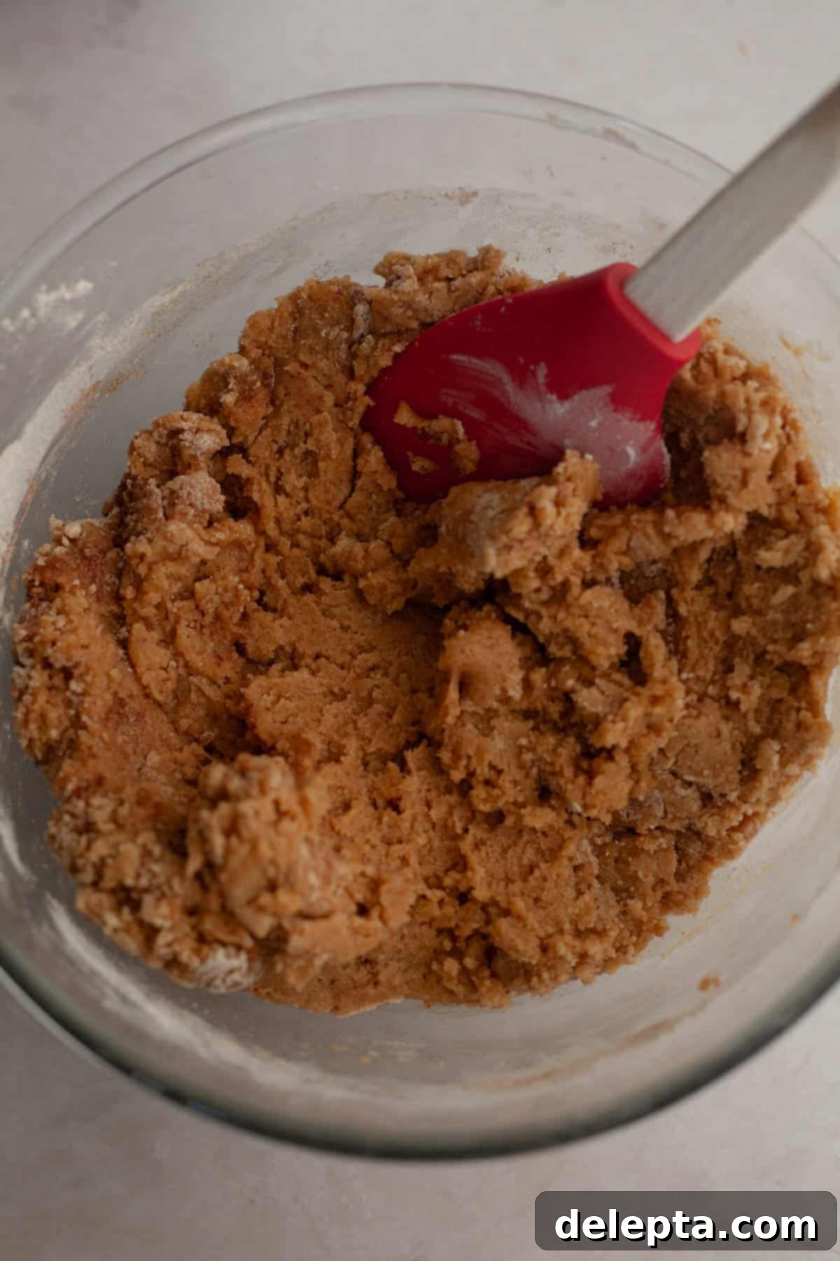 Nutty Brown Butter Chocolate Chip Cinnamon Cookies 7 Brown butter cookie dough in a bowl, with dry ingredients just added and partially stirred, showing streaks of flour.