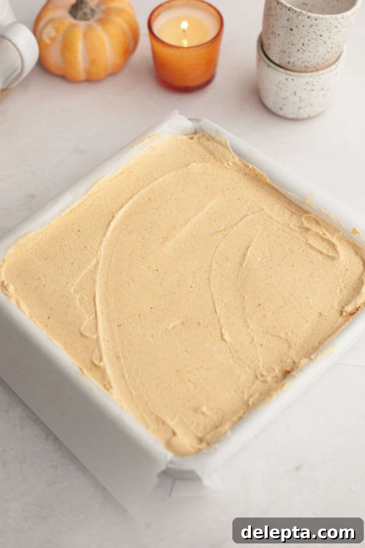 Spiced No-Bake Pumpkin Cheesecake Bars 9 A square pan filled with the smooth pumpkin no bake cheesecake mixture, ready to be chilled overnight.
