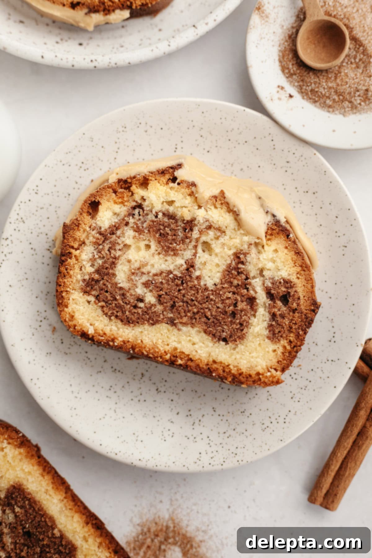 Velvet Cinnamon Pound Cake with Espresso Maple Glaze 12 A delectable slice of cinnamon pound cake with maple espresso glaze on a small white plate, ready to be enjoyed.