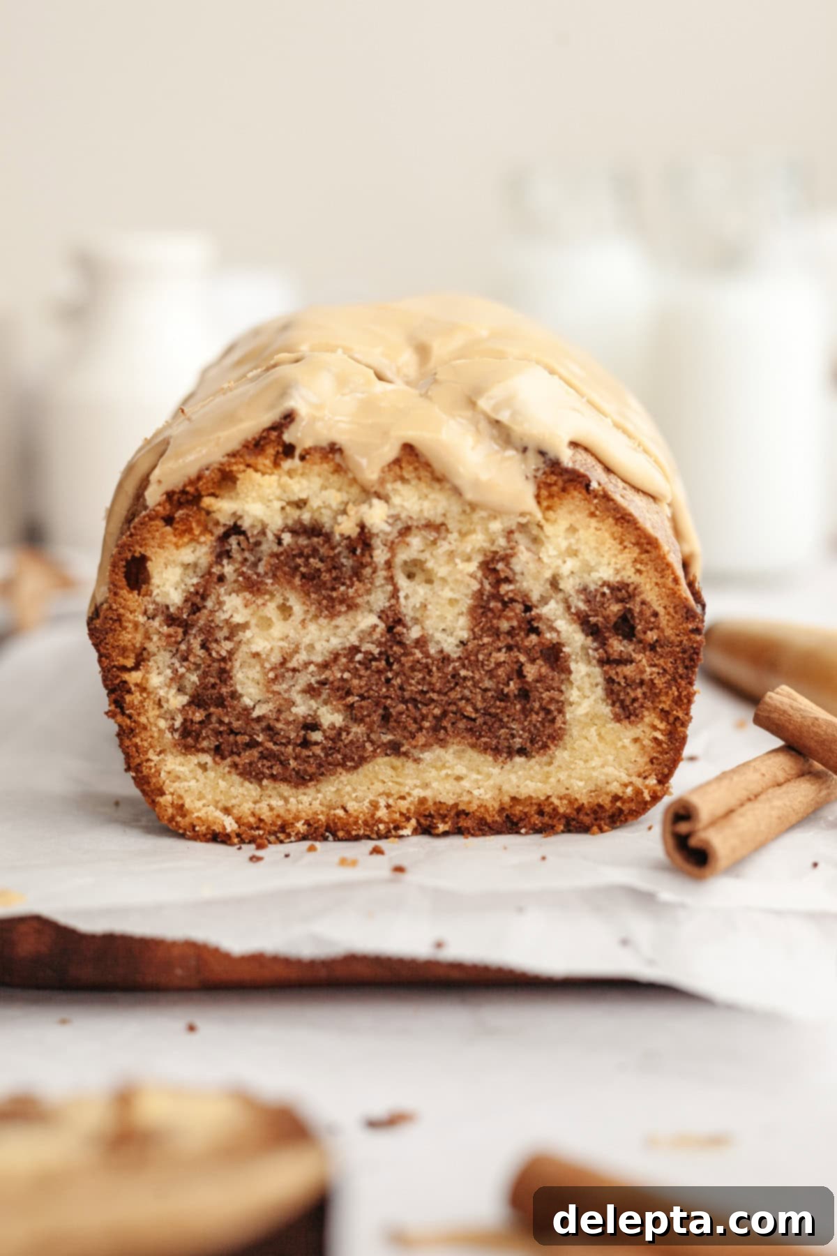 Maple Espresso Glaze 5 A cinnamon pound cake on parchment paper, sliced and ready to serve.