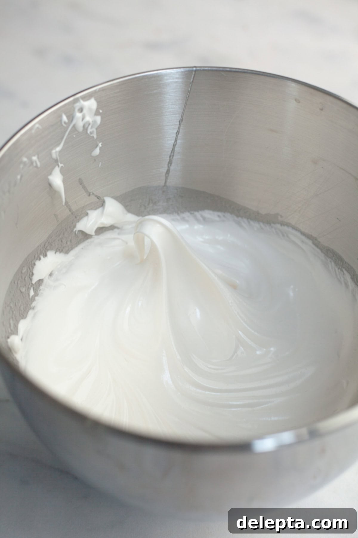 Spiced Pumpkin Cupcakes with Whipped Marshmallow Frosting 10 Glossy white meringue frosting in a stand mixer bowl, whipped to stiff peaks.