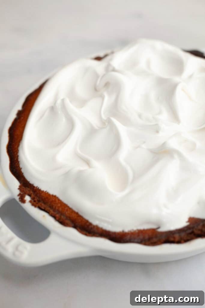 Fluffy Marshmallow Meringue Frosting 6 A beautifully baked pumpkin pie generously covered with fluffy, perfectly toasted marshmallow meringue frosting, ready to be sliced and served.