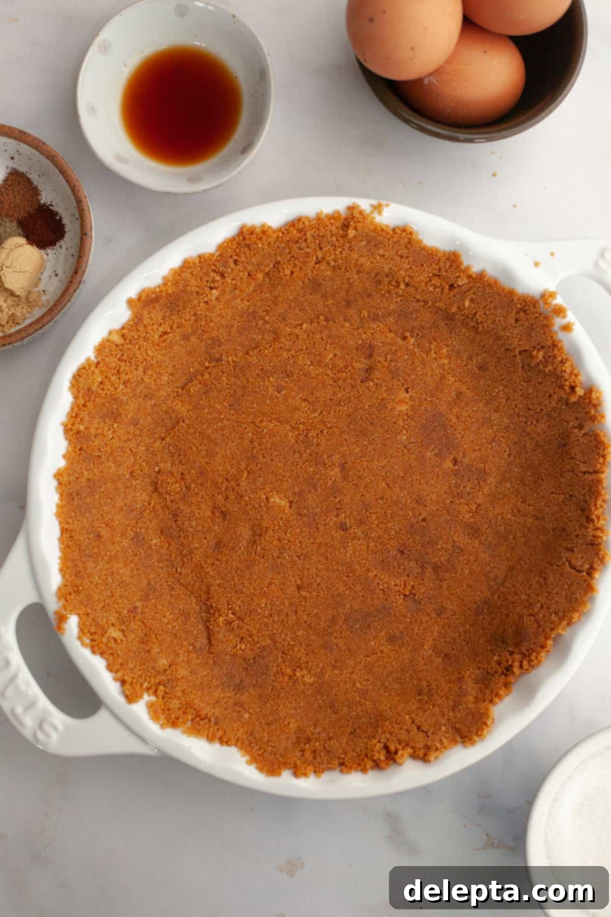 Decadent Brown Butter Pumpkin Pie with Gingersnap Perfection 5 A white ceramic pie dish with a perfectly pressed gingersnap crust, ready for the filling.