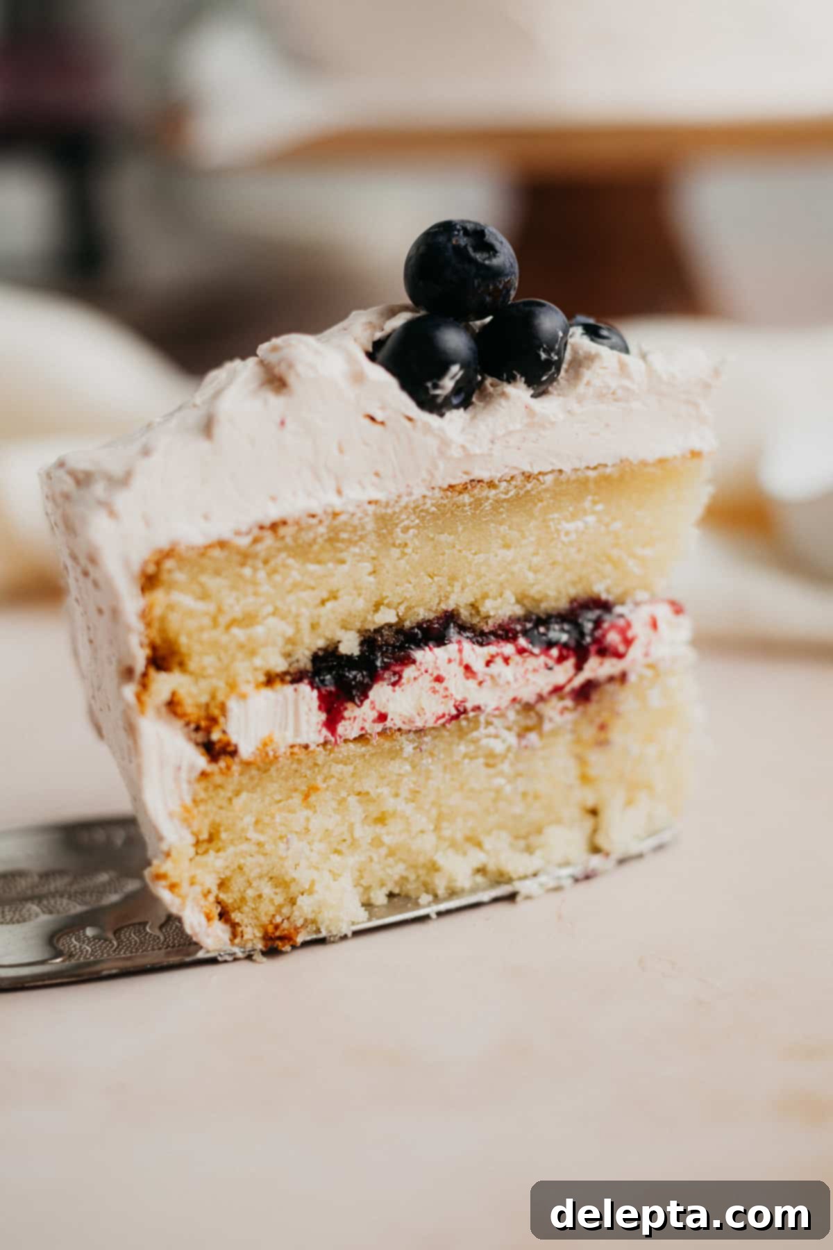 Blueberry Swirl Cake 12 A slice of blueberry jam cake on a silver cake server