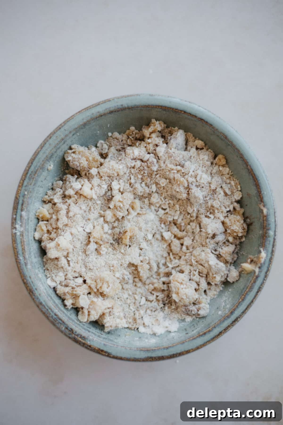 Luscious Strawberry Crumb Cake 5 a small ceramic bowl with an oat crumble topping