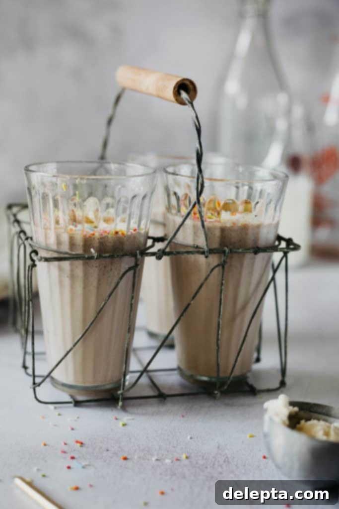 Frosty Funfetti Shakes 4 Three beautifully presented glasses filled with vibrant birthday cake milkshake, topped with sprinkles