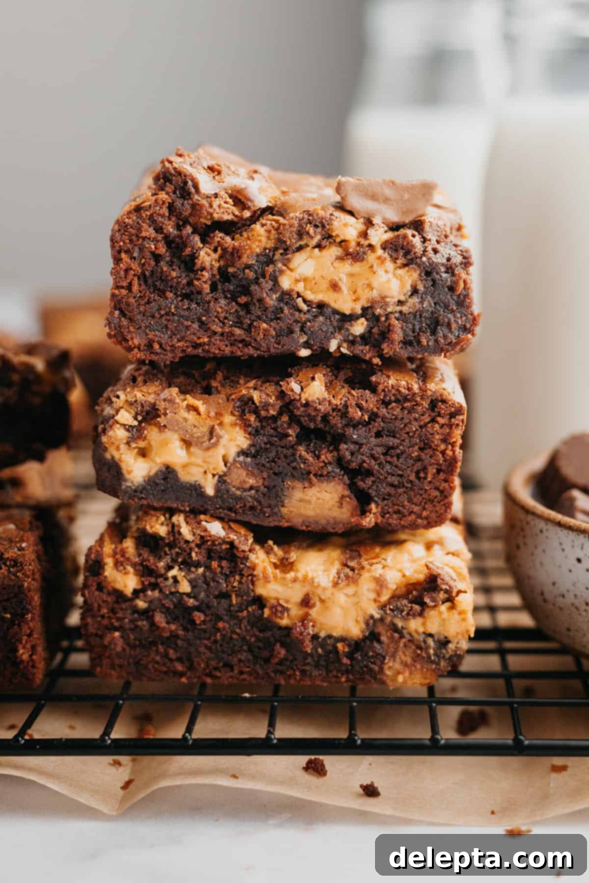 Peanut Butter Cup Brownie Bliss 8 A perfectly stacked trio of fudgy brownies with peanut butter cups, highlighting their rich texture.