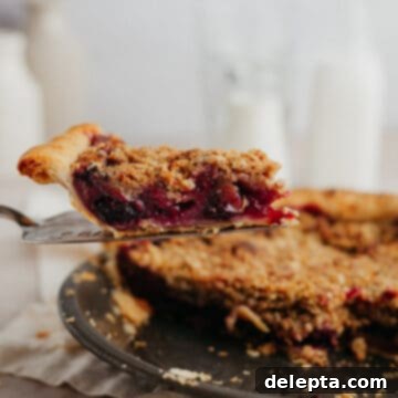 Homestyle Cherry Rhubarb Pie 14 A slice of cherry rhubarb pie being lifted out of the pie plate