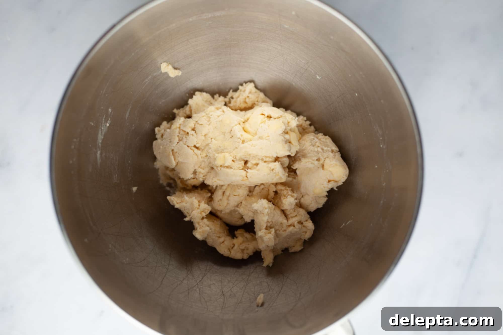 Homestyle Cherry Rhubarb Pie 7 An overhead shot of pie dough in a silver mixing bowl