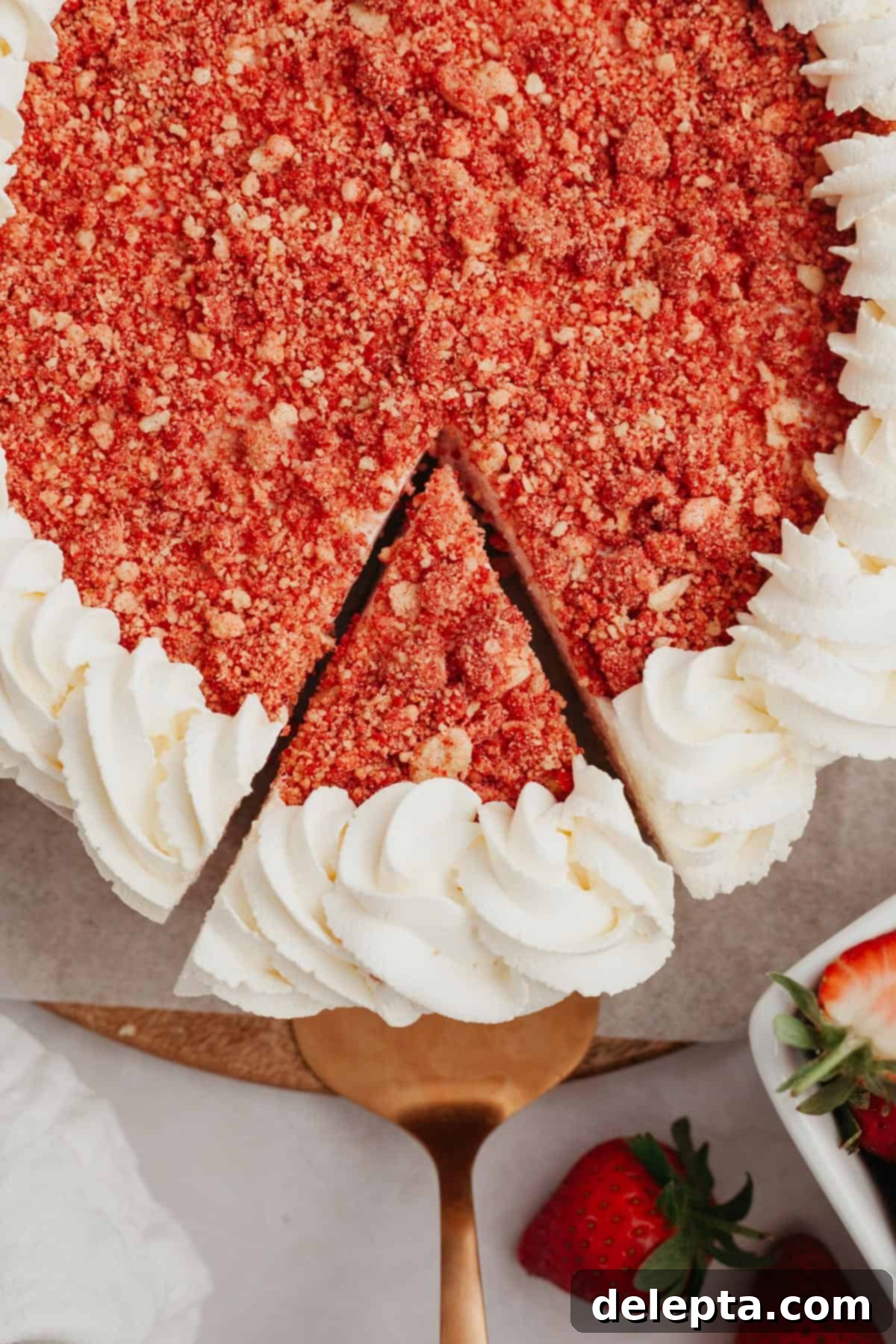 Divine No-Bake Strawberry Crunch Cheesecake 10 A beautifully presented strawberry crunch cheesecake with one perfect slice already removed, showcasing its layers.