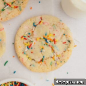 Pillowy Soft Rainbow Sugar Cookies 9 A sprinkle sugar cookies on parchment paper.