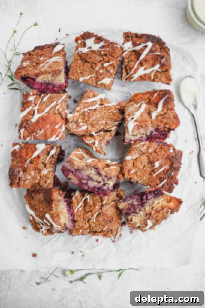 Blackberry Streusel Buckle with Cream Cheese Drizzle 6 A platter of baked blackberry buckle bars, garnished with a light dusting of icing sugar.