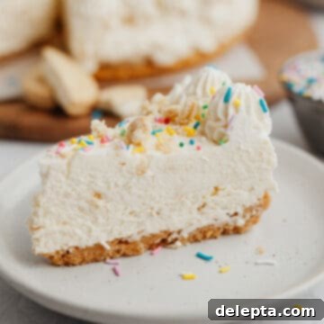 Blonde Oreo Cheesecake 13 A delicious slice of no-bake Golden Oreo cheesecake, elegantly topped with rainbow sprinkles and resting on a small beige plate.