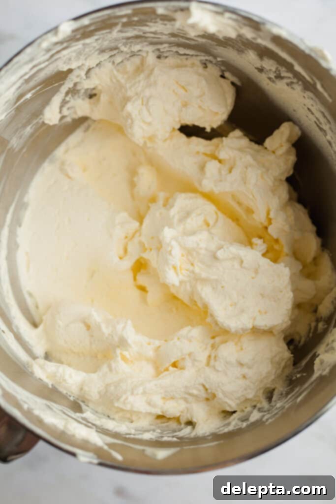 Blonde Oreo Cheesecake 8 A silver mixing bowl containing perfectly smooth cheesecake batter, showcasing its creamy consistency.