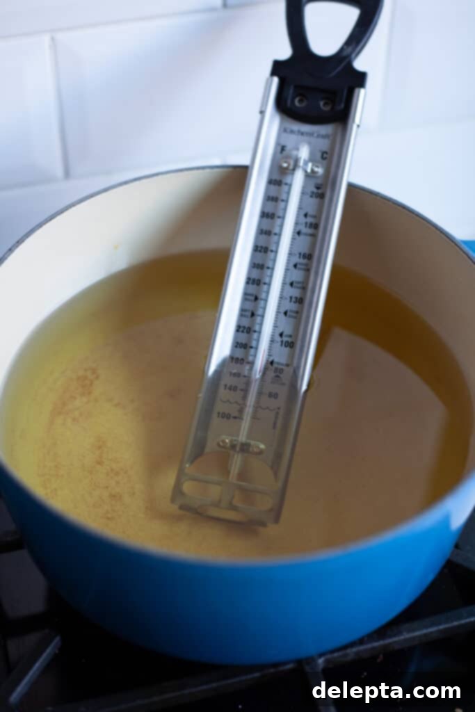 Chocolate-Stuffed Brioche Bliss 12 A heavy cast iron pan filled with oil, there is a thermometer in the oil.
