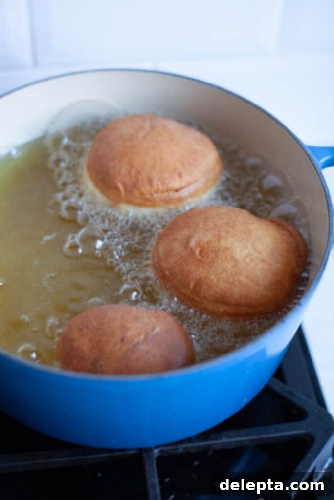 Chocolate-Stuffed Brioche Bliss 13 A large cast iron casserole dish, filled with hot oil. Three doughnuts are frying in it