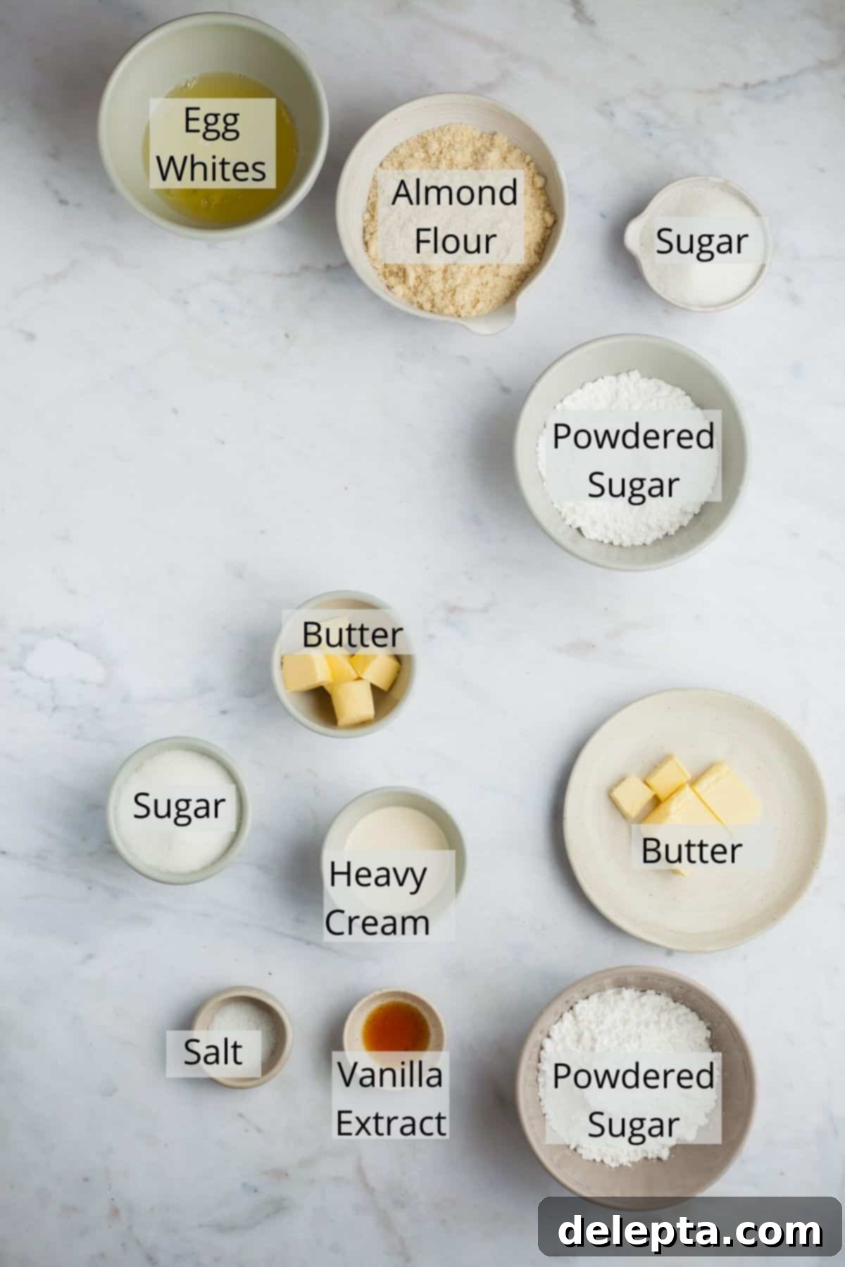 Sea Salt Caramel Macarons 3 A flat lay of all ingredients needed for salted caramel macarons including almond flour, powdered sugar, eggs, butter, heavy cream, and salt.