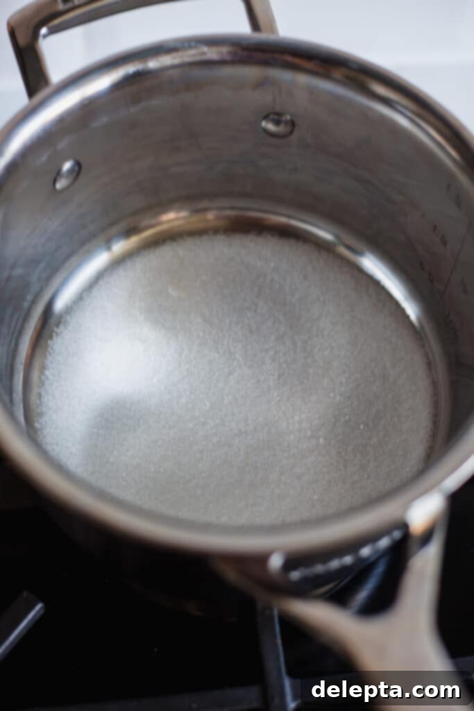 Sea Salt Caramel Macarons 10 A small silver saucepan with a thin, even layer of granulated sugar at the bottom, ready for caramelization.