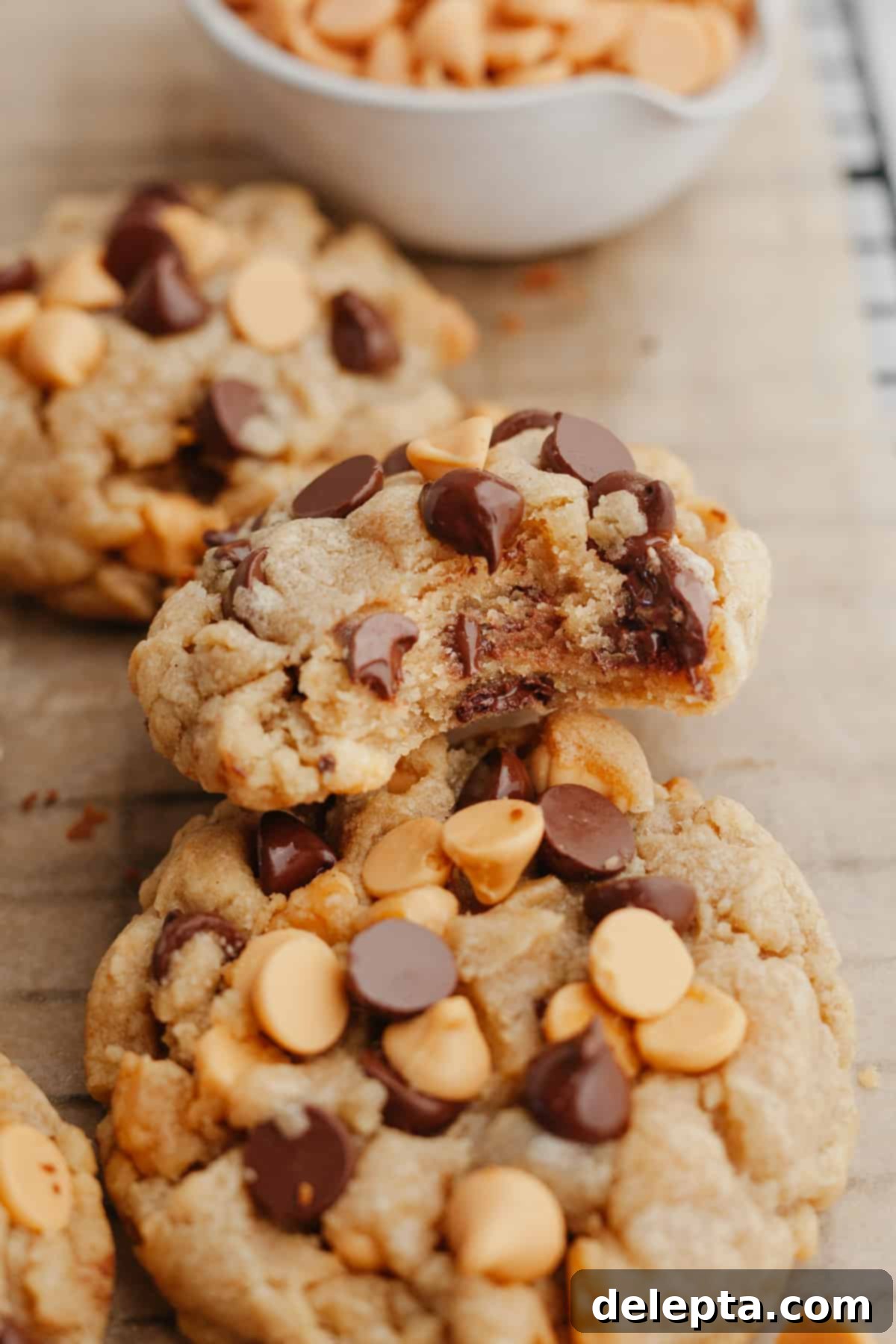 Golden Butterscotch Chocolate Chip Delights 7 A selection of butterscotch chocolate chip cookies on light brown parchment paper, one with a bite taken out, revealing its soft interior.