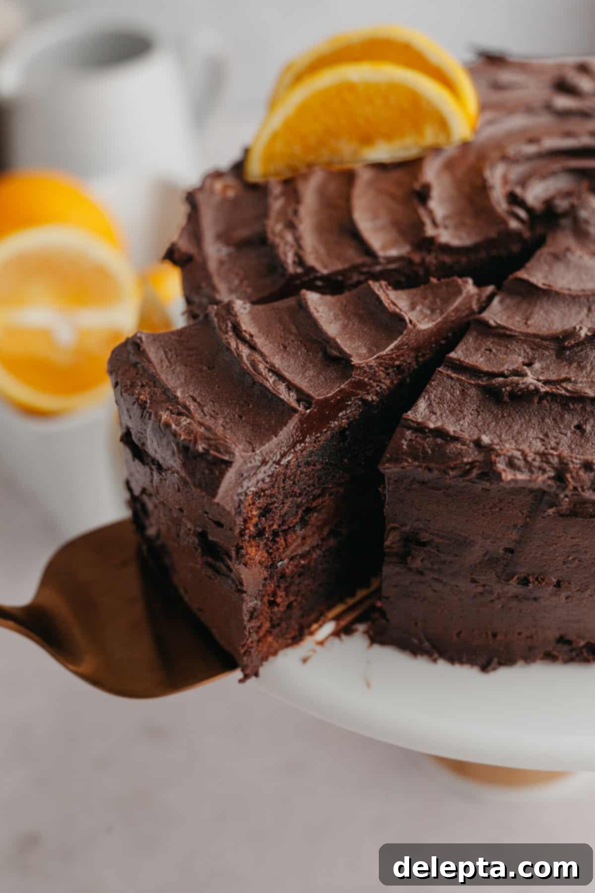 Zesty Chocolate Orange Cake 8 A beautifully presented slice of chocolate orange cake being lifted from the whole cake with a server.