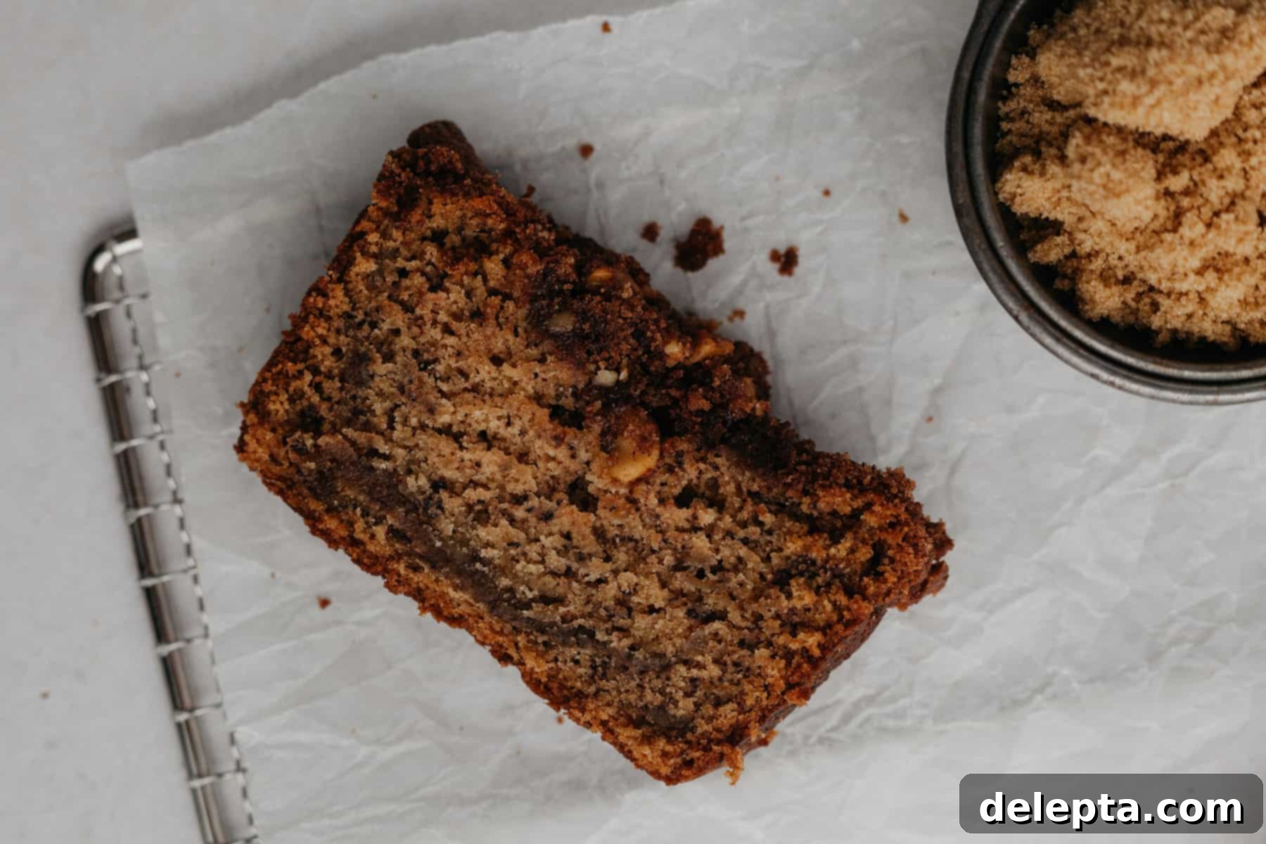 Cinnamon Crumble Banana Bread 5 A perfectly baked slice of cinnamon crunch banana bread on parchment paper, revealing its moist interior and crunchy topping