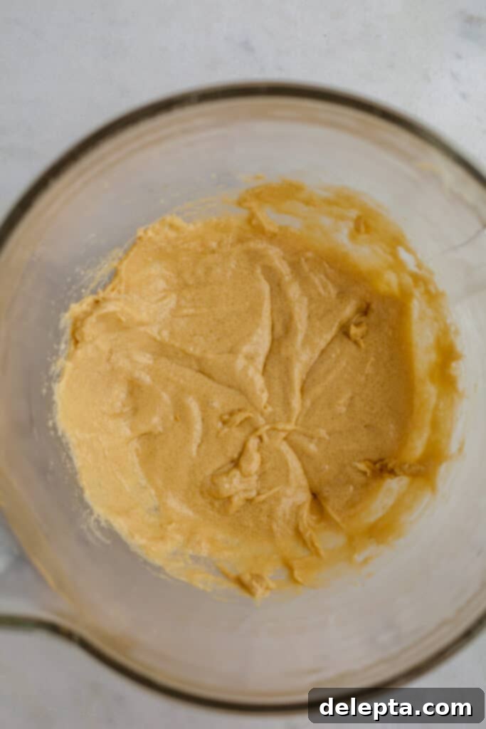 Cinnamon Crumble Banana Bread 10 Smooth banana bread batter in a glass bowl after egg and vanilla have been incorporated
