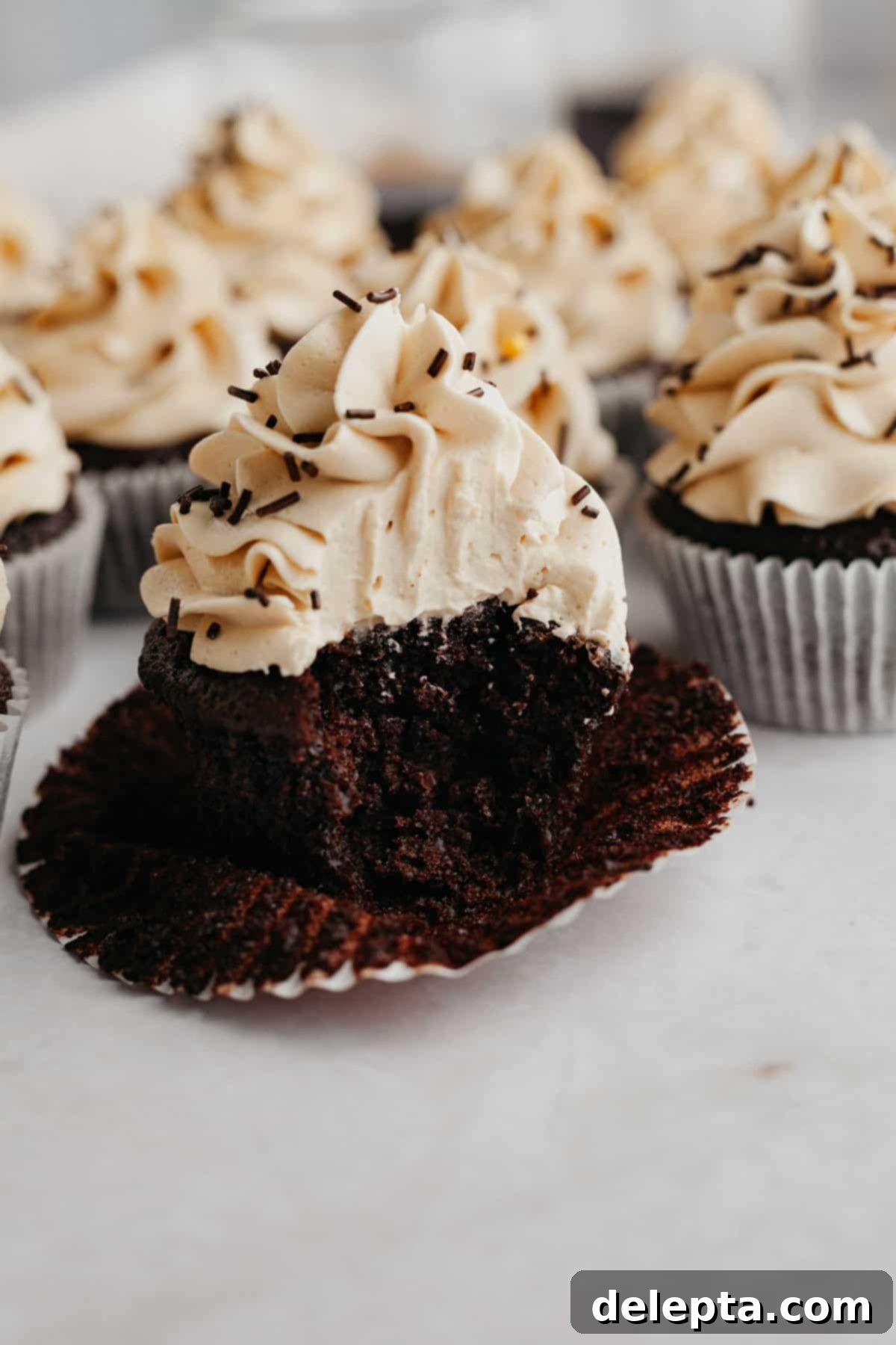 Effortlessly Moist Mocha Cupcakes with Espresso Buttercream 11 A mocha cupcake with a bite taken out of it