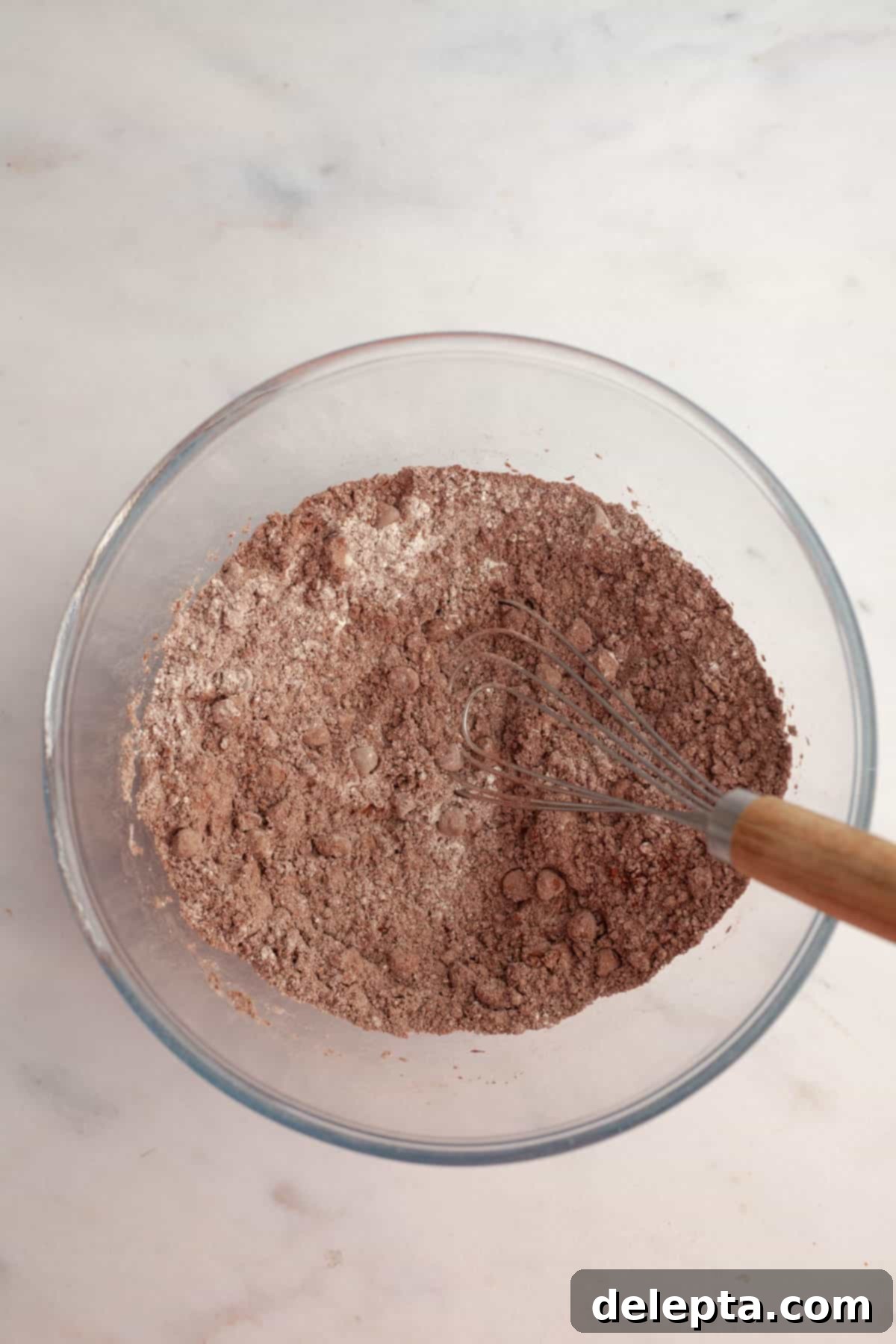 Effortlessly Moist Mocha Cupcakes with Espresso Buttercream 4 A glass bowl with cocoa powder, flour and chocolate chips.