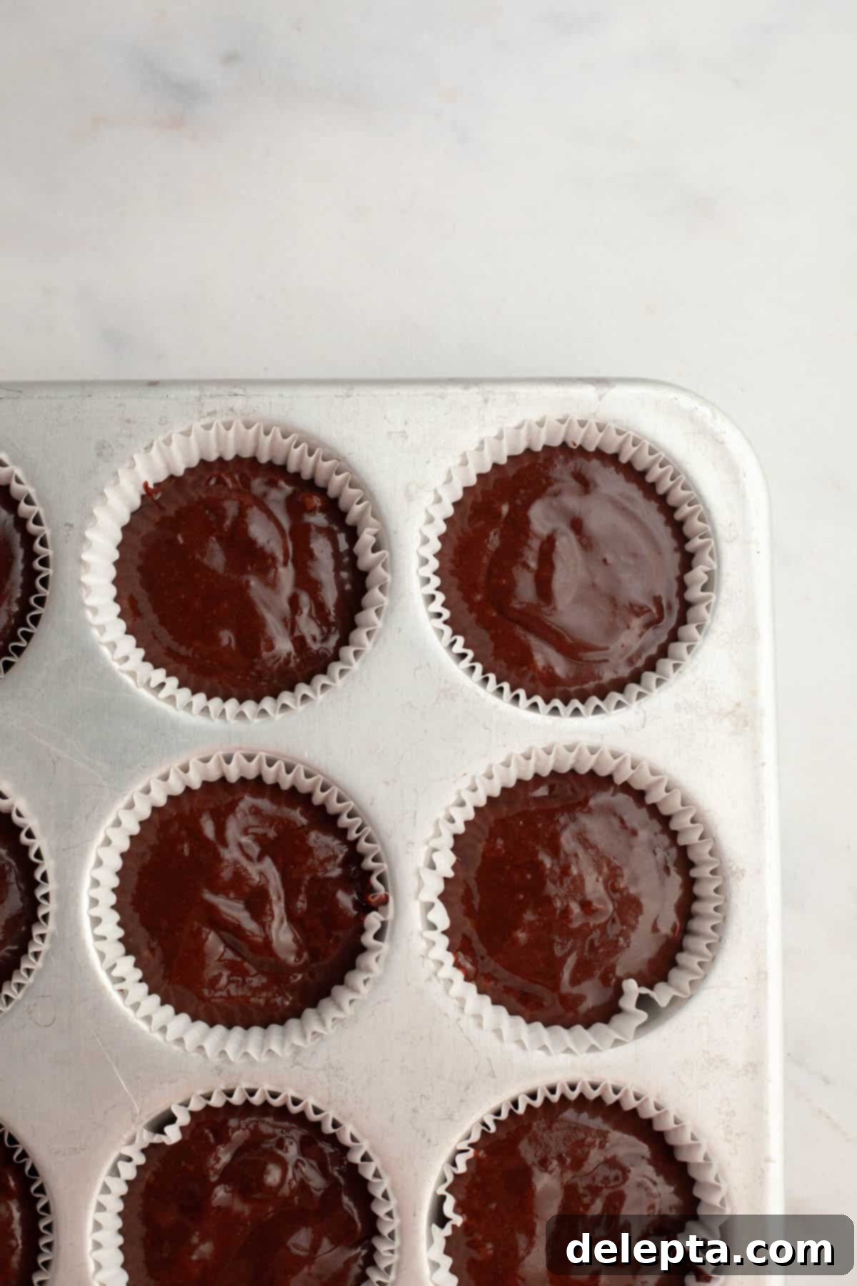 Effortlessly Moist Mocha Cupcakes with Espresso Buttercream 7 Unbaked chocolate cupcakes in a cupcake pan.