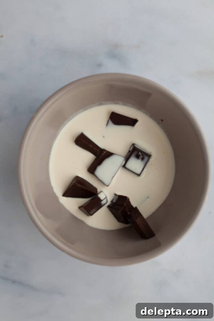 Decadent Oreo Drip Cake 13 A grey bowl with chopped chocolate and heavy cream, ready for melting